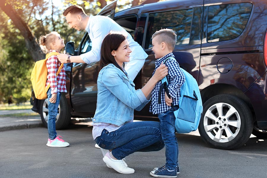 Blog - Parents Getting Their Kids Ready For School in Front of Their Large SUV