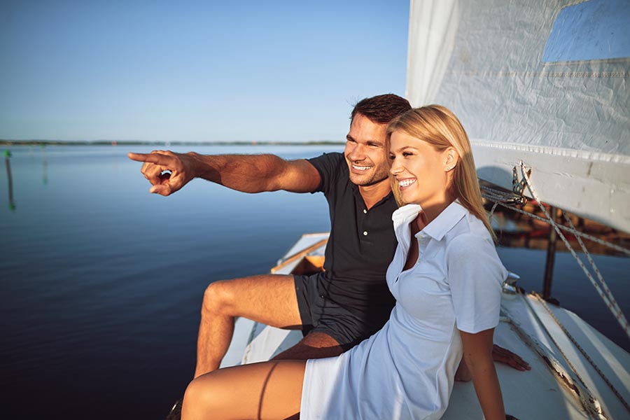 Personal Insurance - Young Couple On a Sailboat on Flat Water on a Sunny Day